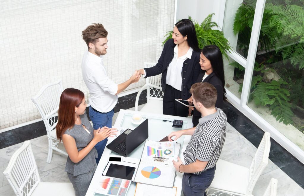 top view of businesspeople shaking hands after sea 2025 01 08 03 51 11 utc scaled 1